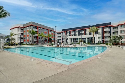 A large swimming pool is surrounded by a building with red and white stripes.